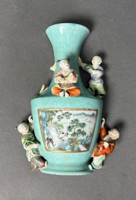 a blue vase with figurines on it on a table