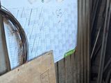 Plusieurs morceaux de bois sont empilés contre un mur dans un garage.