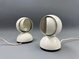 two white lamps sitting on top of a table next to each other