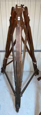 a wooden tripod sitting in the middle of a room