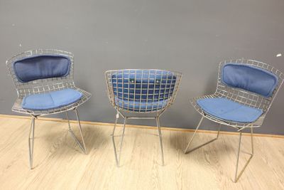 three chairs with blue cushions in a room with wood flooring