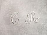 a close up of a white towel with a monogram on it