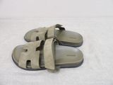 someone is wearing a pair of sandals that are on a bed