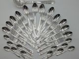 a lot of silver spoons and spoons on the table