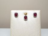 une paire de boucles d'oreilles en rubis et diamants exposée dans une vitrine blanche