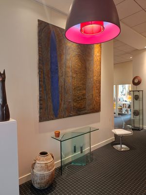 an image of a hallway with art on the wall and a glass table