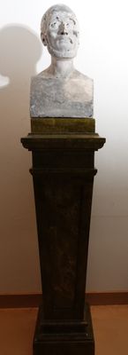 a marble bust of a man sitting on a pedestal