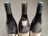 three bottles of wine sitting next to each other on a table