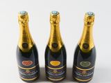 three bottles of champagne sitting next to each other on a white surface