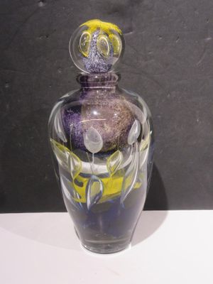 a glass vase with a purple and yellow design on it