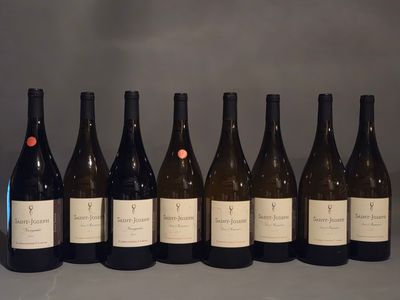 six bouteilles de vin sont alignées sur une table