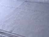 une pile de draps blancs sur un lit recouvert d'une couette bleue