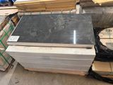 un tas de granit noir posé sur une palette dans un entrepôt