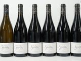 six bouteilles de vin sont alignées sur une table