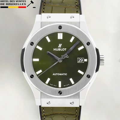 an image of a close up of a wrist watch with a green dial
