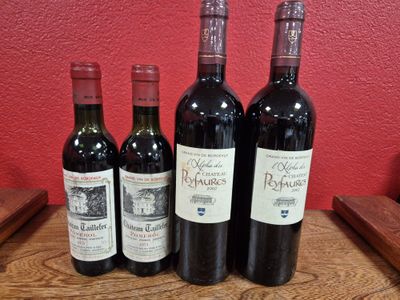 four bottles of wine are lined up on a wooden table