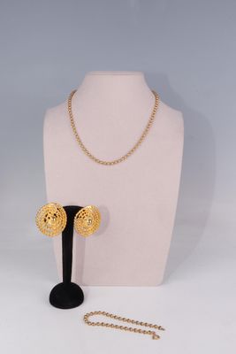 un mannequin blanc portant un collier et des boucles d'oreilles en or