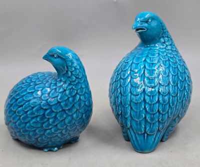 pair of blue ceramic birds sitting next to each other on a table