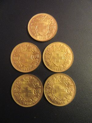 quatre pièces d'or posées sur une surface noire