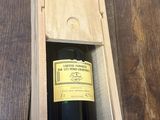 une bouteille de vin dans un coffret en bois sur une table