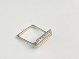 gros plan d'une bague en argent sur une surface blanche