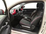 the interior of a small white car with black seats and a red steering wheel