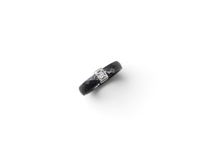 an image of a black and white diamond ring on a white surface
