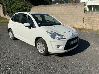 a picture of a small white car parked on the side of the road