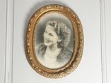 an old picture of a woman with a pearl necklace in a gold frame