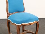 une image représentant une chaise bleue avec une structure en bois et une assise rembourrée bleue