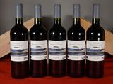 four bottles of wine are lined up on a table