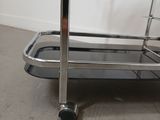 a metal cart with a handle on it in the middle of a room