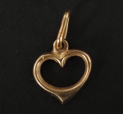 un pendentif en forme de cœur doré sur fond noir