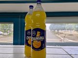 two bottles of orange juice on a shelf in a store