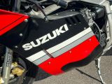 un gros plan d'une moto Suzuki garée sur un parking