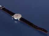 an image of a close up of a wrist watch on a blue surface