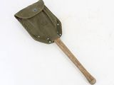 a small shovel with a wooden handle on a white surface