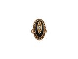 une bague noire et dorée ornée d'un diamant au centre