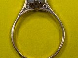 une bague en argent sertie d'une perle, sur un fond jaune