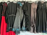 un grand nombre de robes suspendues à une étagère dans une pièce