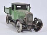a green toy truck that is sitting on a white surface