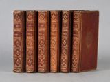 four old books sitting on top of each other on a table