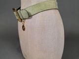 a close up of a mannequin head with a green belt