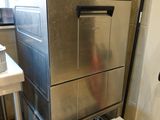 a silver dishwasher sitting on top of a metal rack in a kitchen