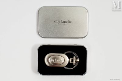 une petite boîte en métal contenant un porte-clés en métal