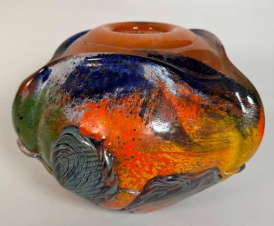 a vase with a colorful design on it sitting on a table