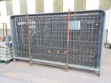 a large metal cage with a bunch of crates behind it