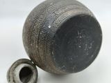 a small black vase with a hole in the middle