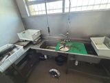 a kitchen with a sink and a green cutting board