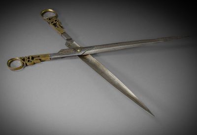 a pair of scissors on a table with a black background
